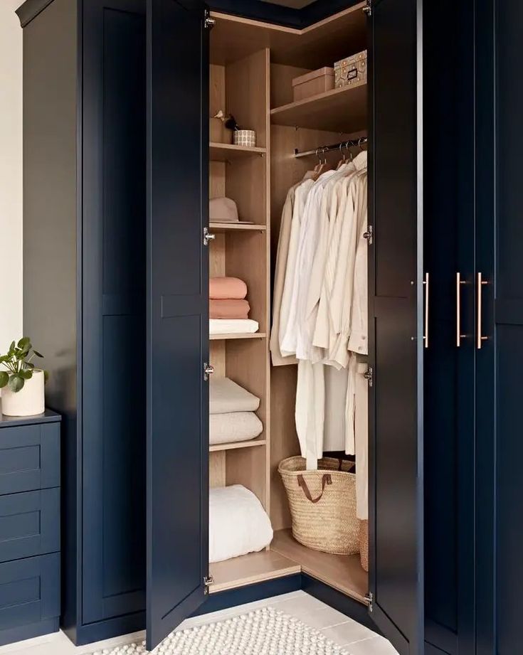 an open closet with clothes and towels in it