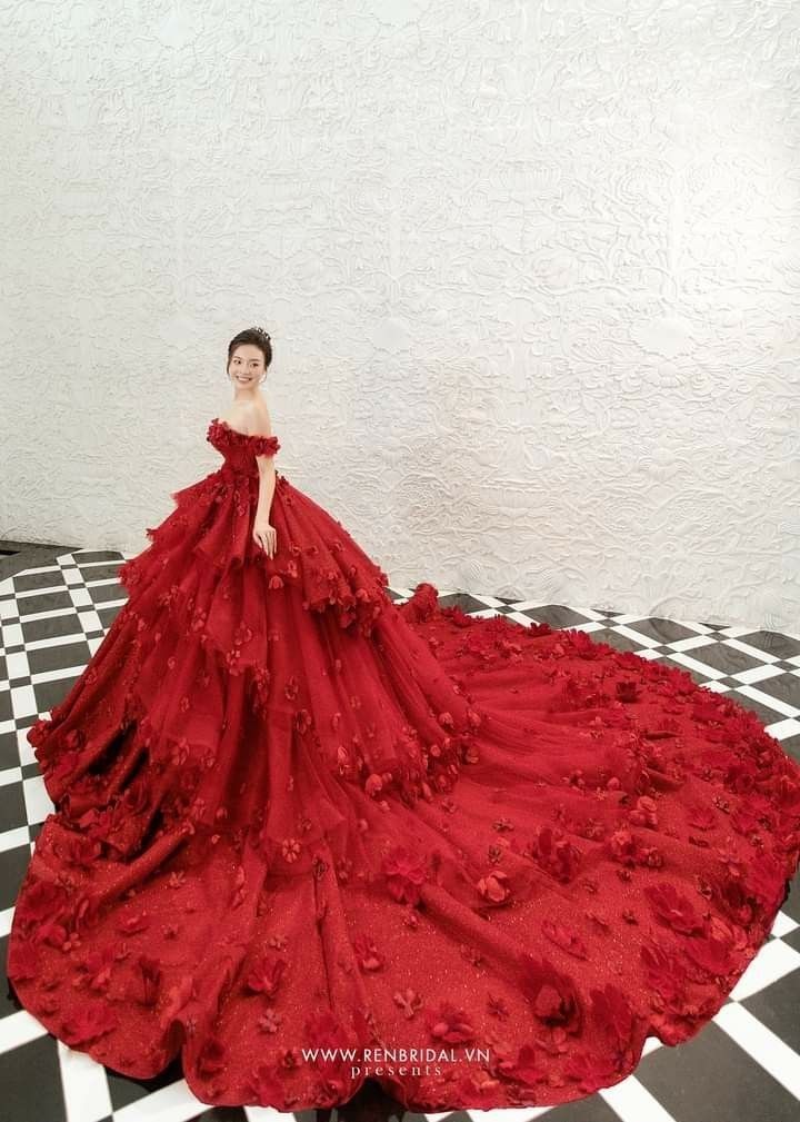 a woman in a red dress standing on a black and white checkered floor