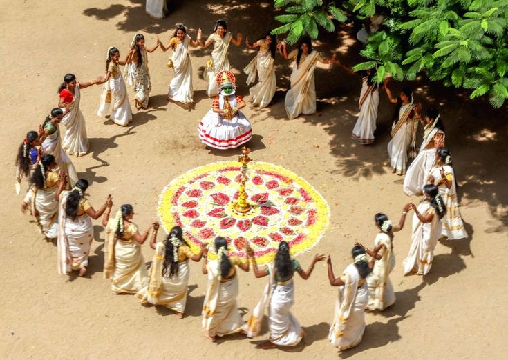 a group of people standing around a flower arrangement in the middle of a dirt field