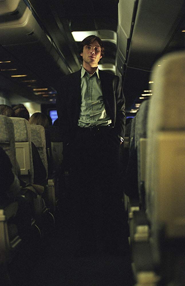 a man standing in the aisle of an airplane