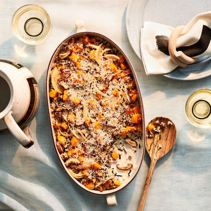 a casserole dish with pasta and cheese in it on a blue table cloth