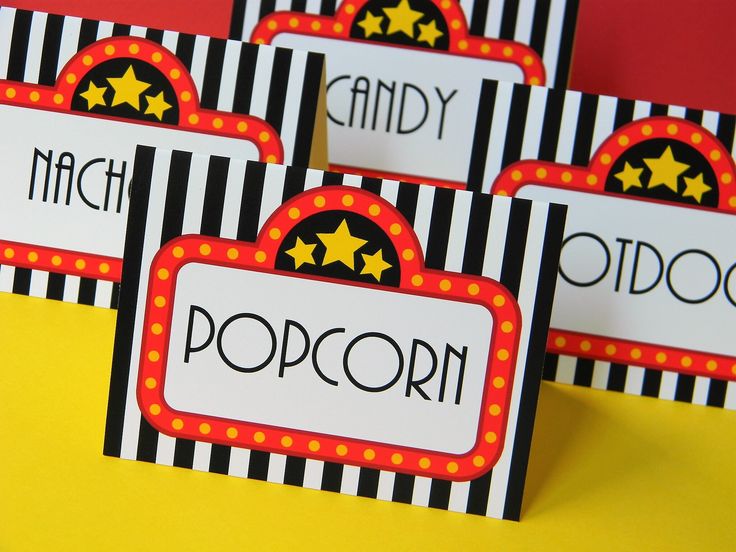 four black and white striped name tags with gold stars on them, sitting on a yellow surface