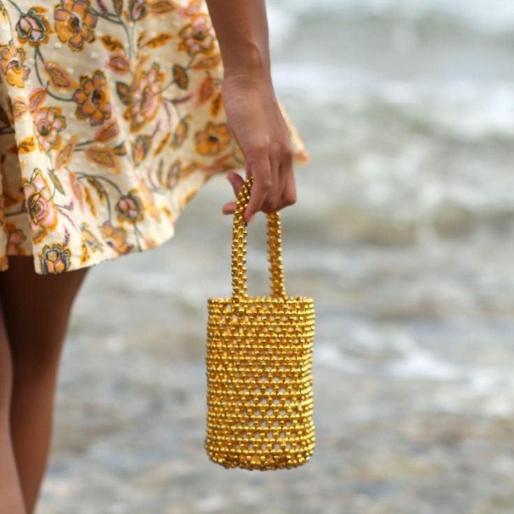 Vacation season is never complete without a novelty bag to create picture-perfect Instagram shots. Introducing GOLDA, the ultra-desirable bucket bag with the Bali X Cali-infused style. Feel nature’s energy in the palm of your hand as you tote the GOLDA Metallic Beads Bucket bag in gold beads color on a sunny day at the beach. The shimmering metallic beads reflect the sunlight, creating a beautiful play of light and color. Completed with a drawstring pouch to keep your belongings secure, GOLDA Me Gold Rectangular Bucket Bag With Removable Pouch, Gold Pouch Bucket Bag As Gift, Gold Pouch Bucket Bag Gift, Trendy Gold Rectangular Bucket Bag, Gold Bucket Bag For Travel, Gold Bucket Bag With Removable Pouch, Trendy Gold Bucket Bag With Removable Pouch, Gold Tote Mobile Phone Bag, Gold Tote Bag For Mobile Phone