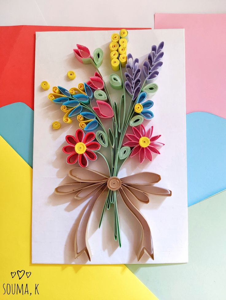 a greeting card with flowers made out of paper on top of multicolored papers