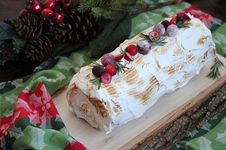 a piece of cake sitting on top of a wooden cutting board next to pine cones