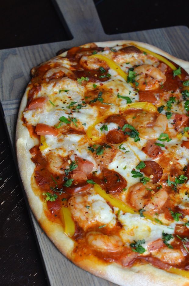 a pizza sitting on top of a wooden cutting board