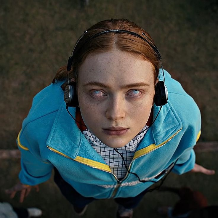 a woman with headphones on looking up at the camera