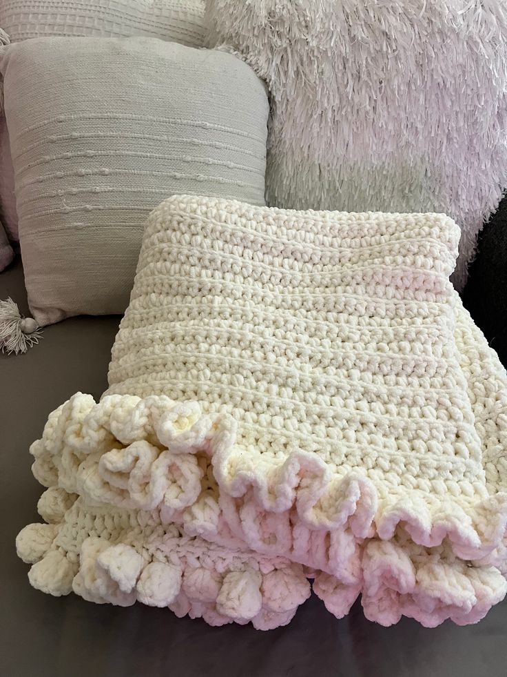 a white crocheted blanket sitting on top of a couch