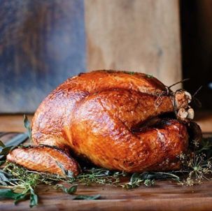 a roasted turkey on a wooden cutting board