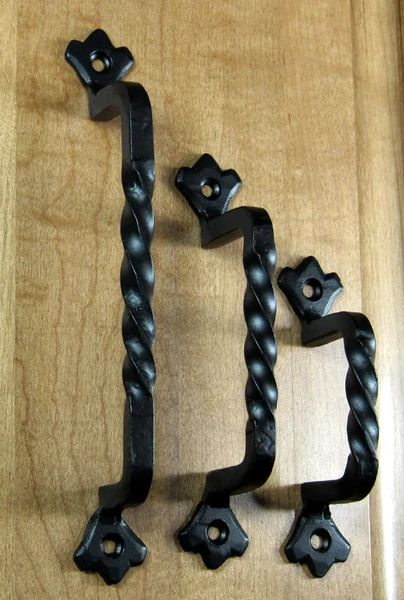 two black iron door handles on a wooden surface