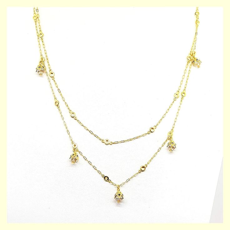 This beautiful necklace has a unique design - a very long chain that can be worn long or doubled, with the help of a toggle closure. It features tulip-shaped crystal drops set along half of the chain. Made of durable and beautiful 14kt gold-plated brass and enhanced with the finest European crystals. The full length is 42" or 20" when doubled. Made in the USA by La Vie Parisienne Elegant Dangle Double Chain Jewelry, Gold Crystal Backdrop Necklace For Formal Occasions, Formal Gold Crystal Backdrop Necklace, Gold Dangle Jewelry With Double Chain, Yellow Gold Crystal Necklace With Adjustable Chain, Gold Crystal Drop Necklace, Elegant Gold Crystal Drop Necklace, Gold Crystal Lariat Necklace, Gold Cubic Zirconia Crystal Necklaces For Jewelry Making