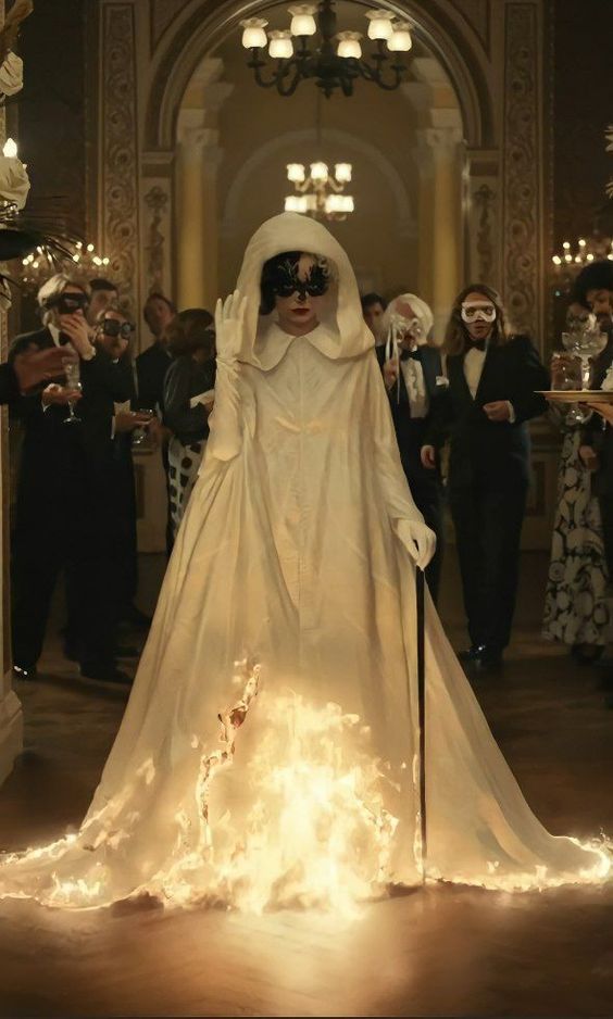 a woman dressed in white is walking through a hall with many other people and lights