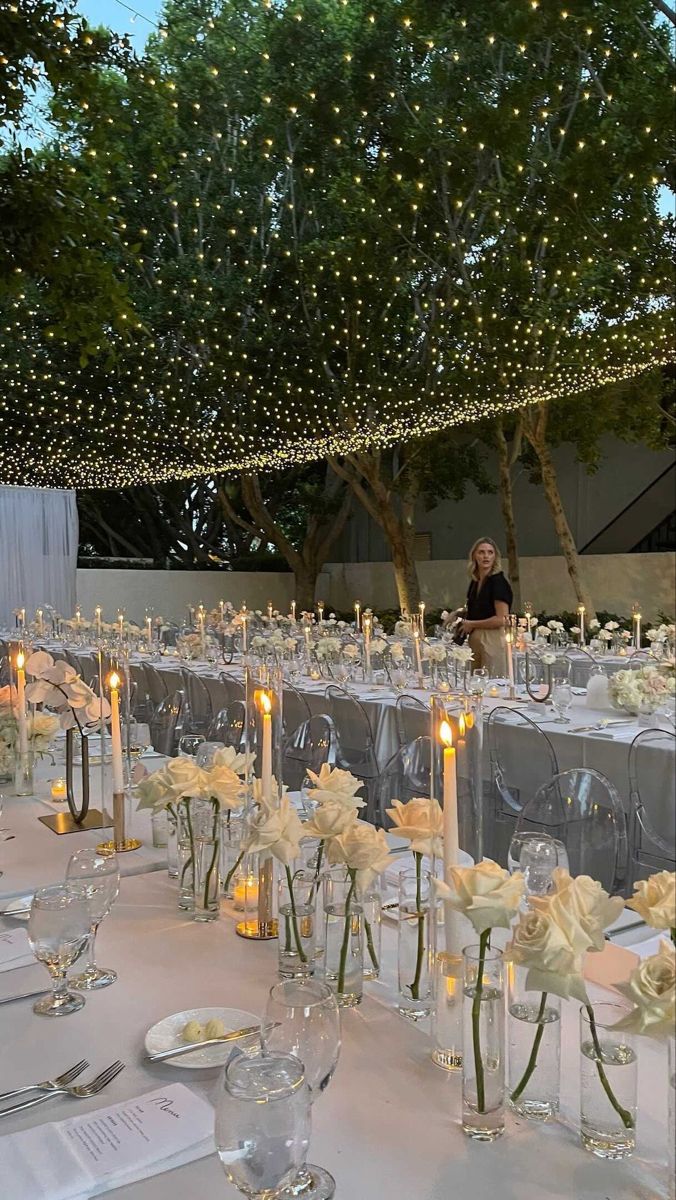 the tables are set with candles and centerpieces for an elegant wedding reception at night