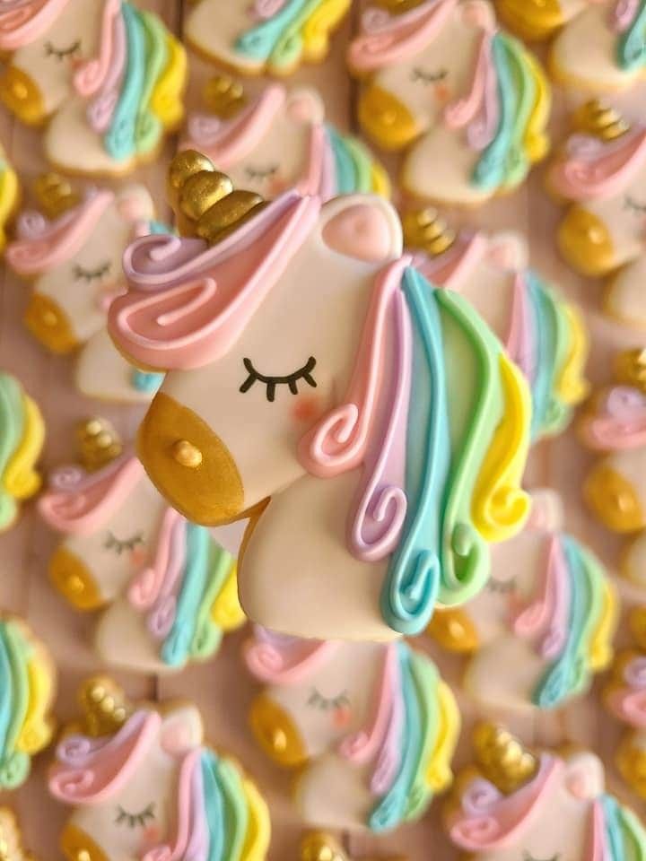 the cookies are decorated with pastel colors and have a unicorn's face on them