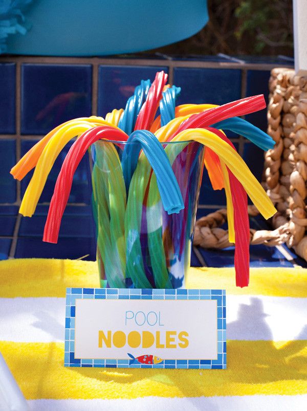 a vase filled with colorful plastic straws on top of a table