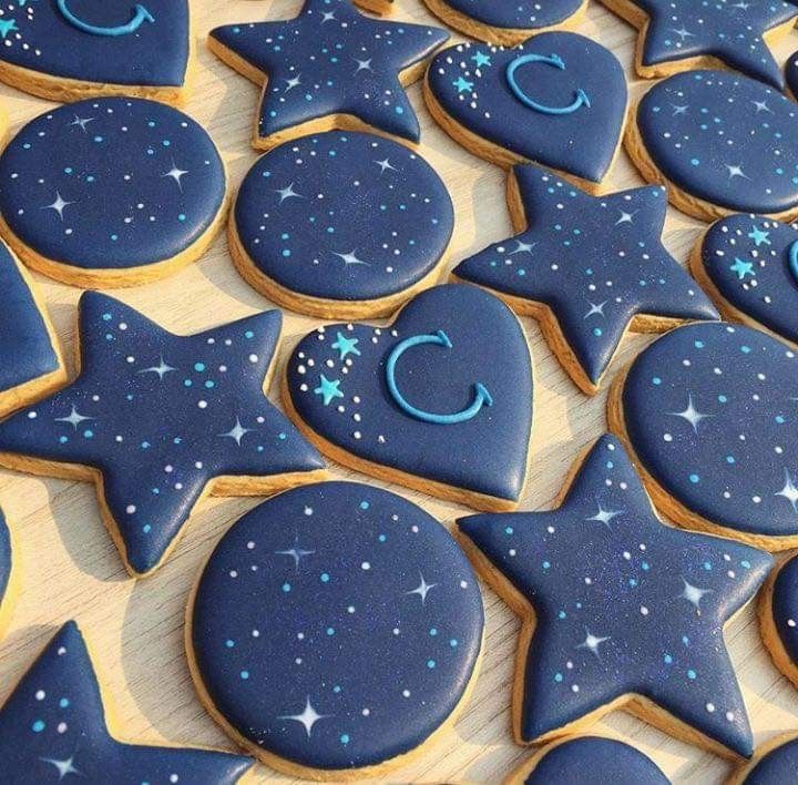 cookies decorated with blue icing and stars on a table