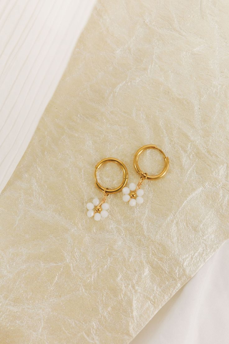 Spruce up your outfit with these playful Dropping Daisies Earrings! These gold hoops feature a charming white beaded flower design with a gold center, adding a touch of whimsy to your look. Perfect for adding a fun and unique twist to any outfit. Gold earrings White beaded flower design with gold center Huggie/hoop earrings with dropped flowers Daisies Earrings, Nursing Friendly Tops, Free People Sandals, Thread Wallets, Nursing Friendly Dress, Huggie Earrings Gold, Wedge Loafers, Daisy Earrings, Earrings White