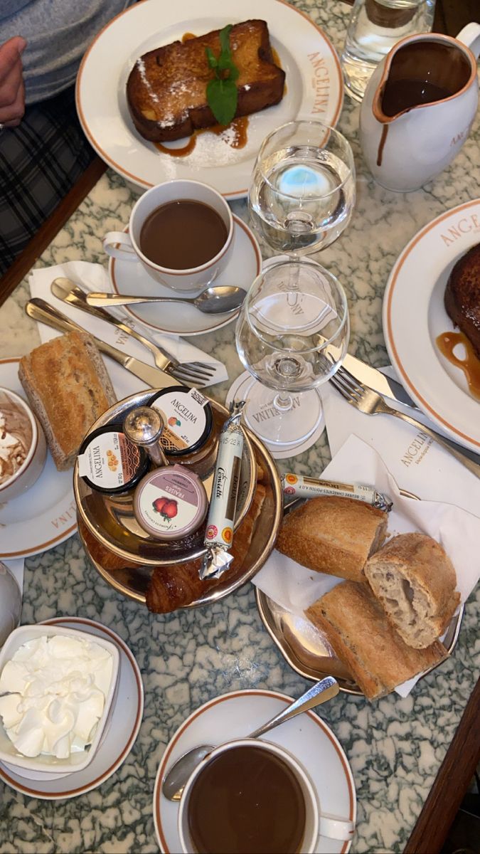 a table topped with plates and cups filled with food