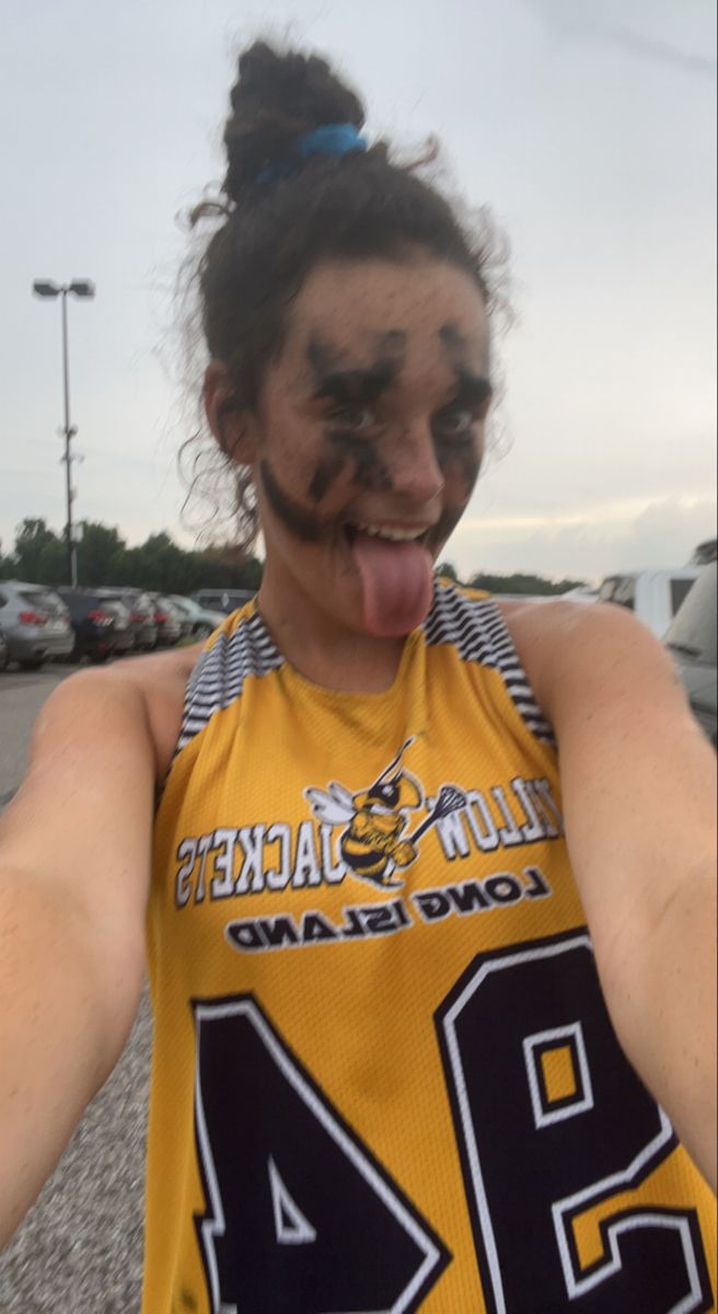 a woman with her tongue out making a funny face while standing in a parking lot