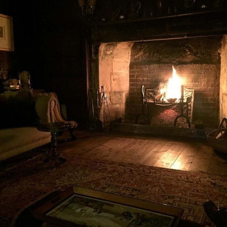 a living room filled with furniture and a fire place in the middle of a fireplace