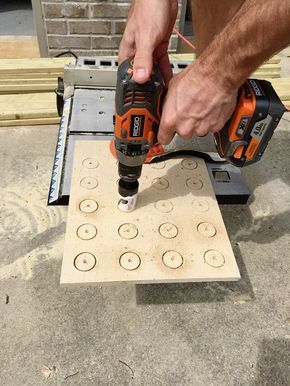 a man is using a drill to cut holes in the floor with a power tool