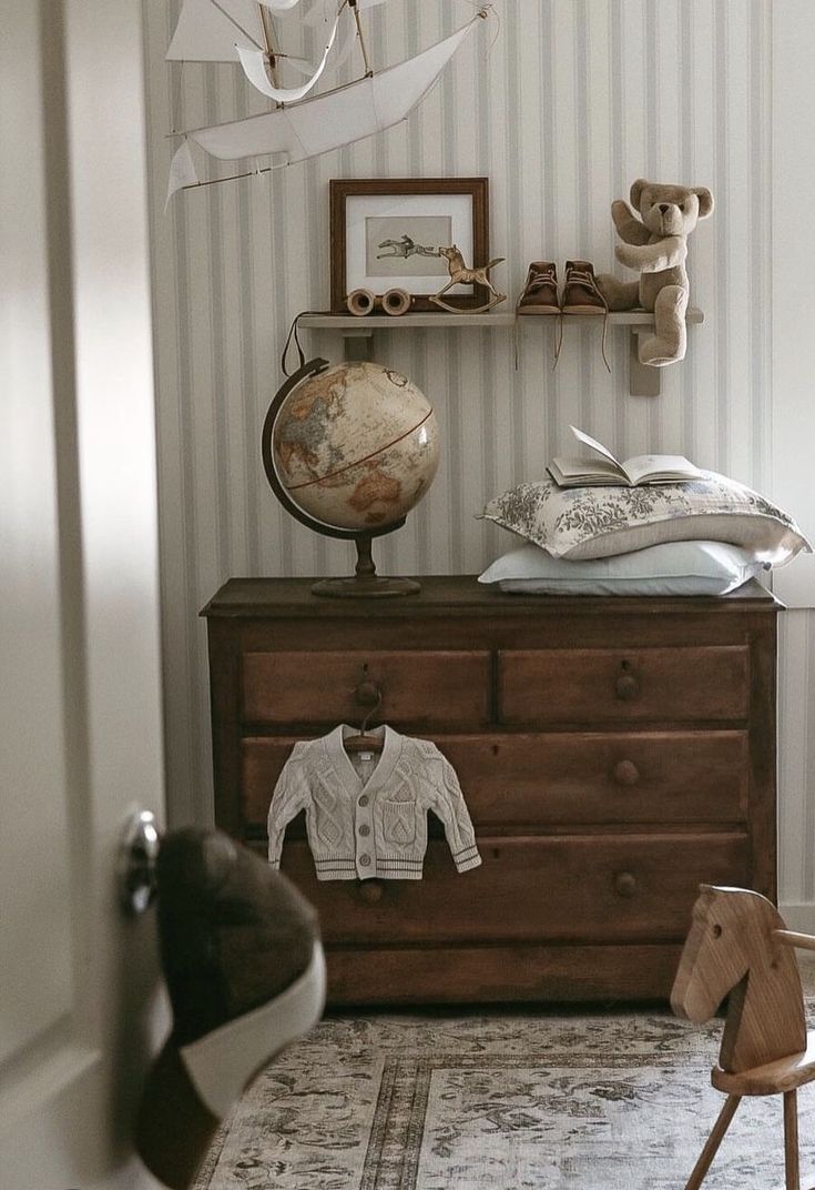 a dresser with a shirt on top of it next to a stuffed animal and other items