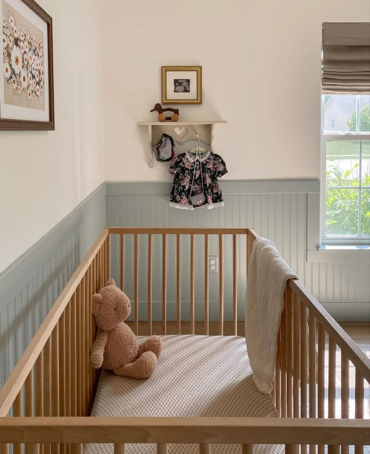 a baby crib with a teddy bear in it