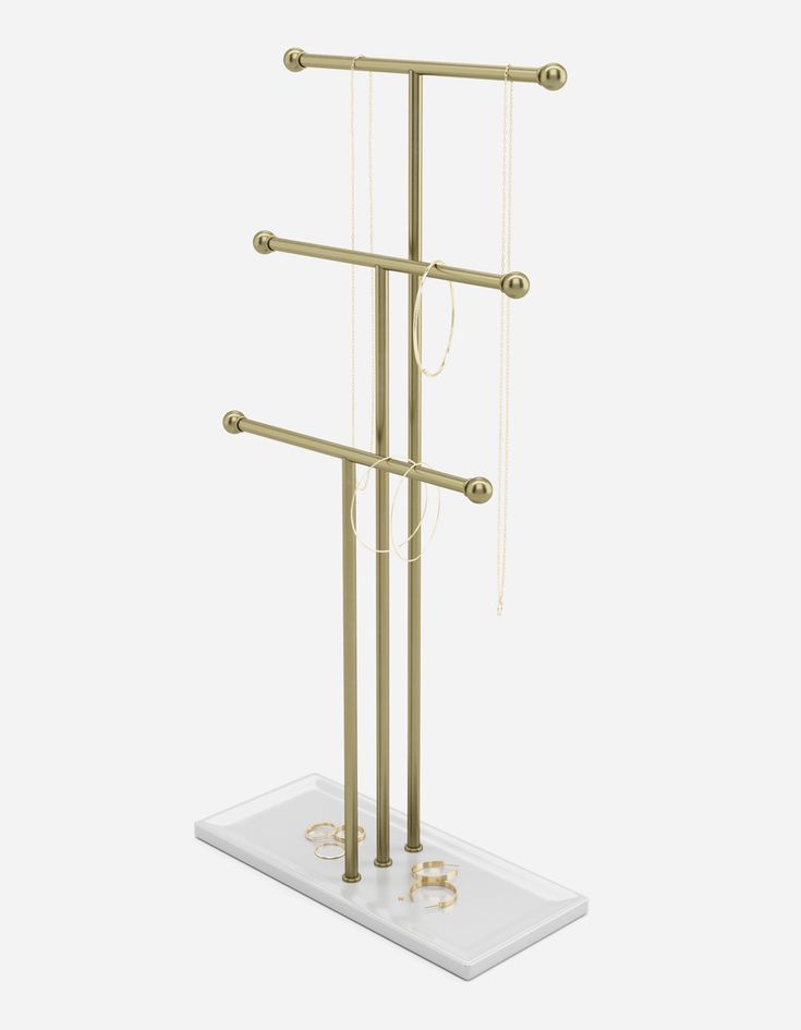 a gold metal jewelry rack with three rings on the top and two chains hanging from it