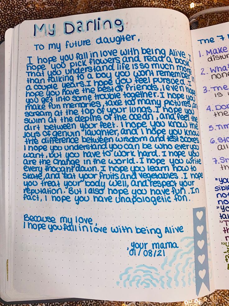 an open notebook with writing on it and some words written in blue ink next to each other