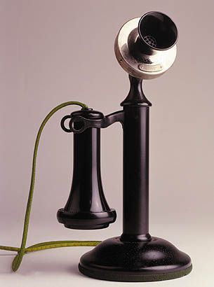 an old - fashioned telephone with a cord attached to it