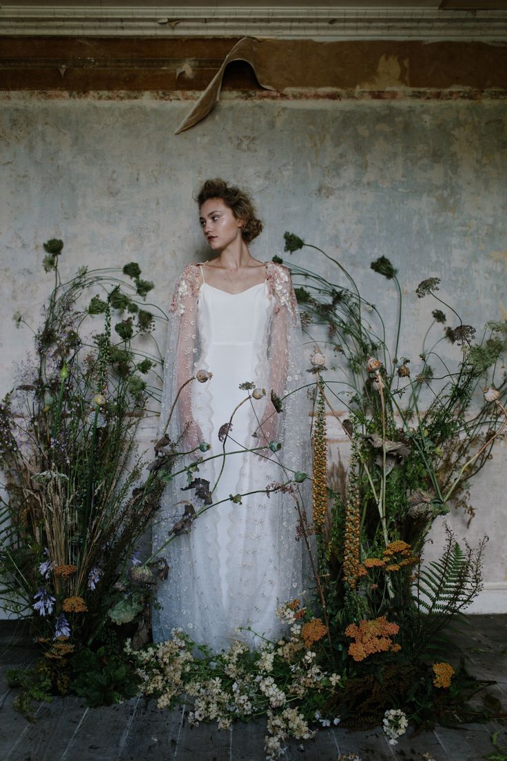 a woman standing in front of flowers and plants