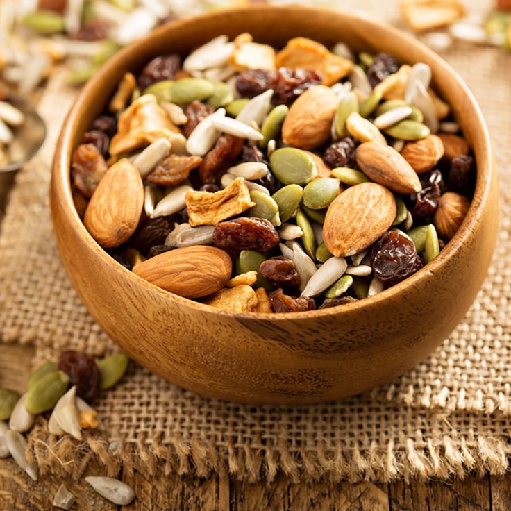 a wooden bowl filled with nuts and raisins