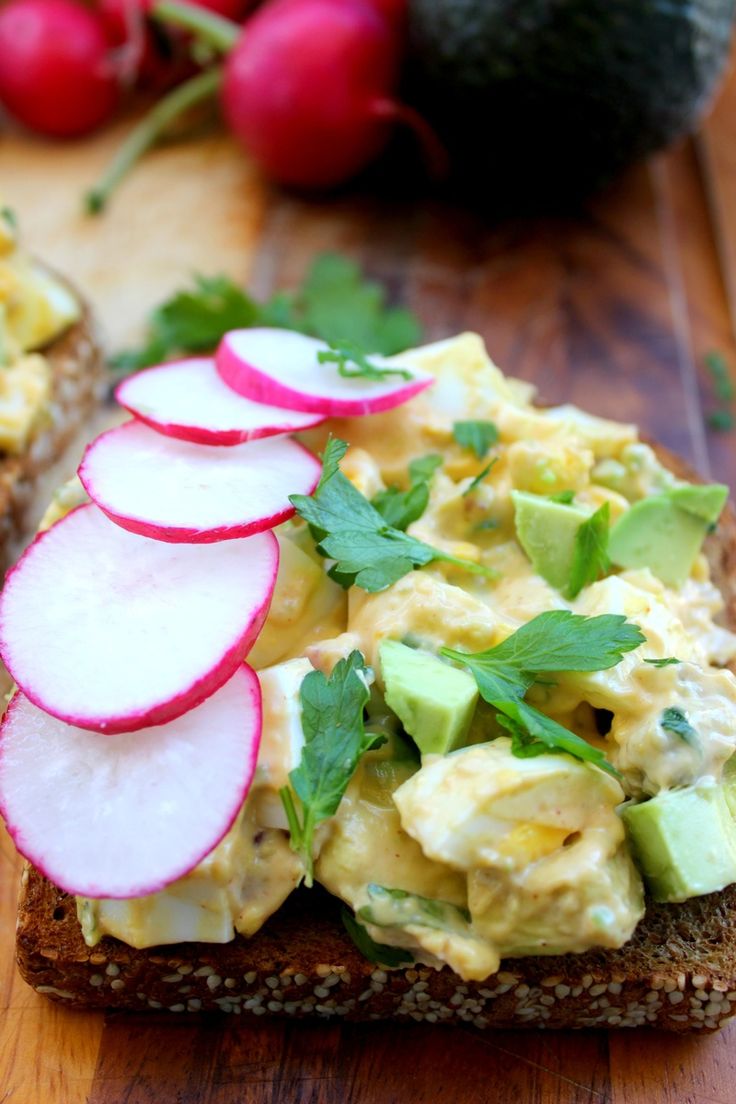 an open face sandwich with avocado and radishes