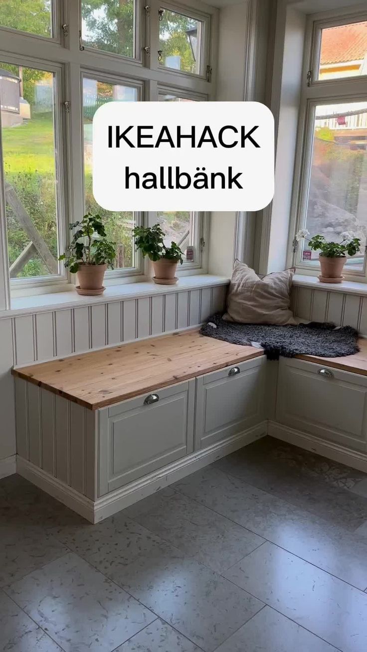 a kitchen with some plants in the window sill and a bench next to it