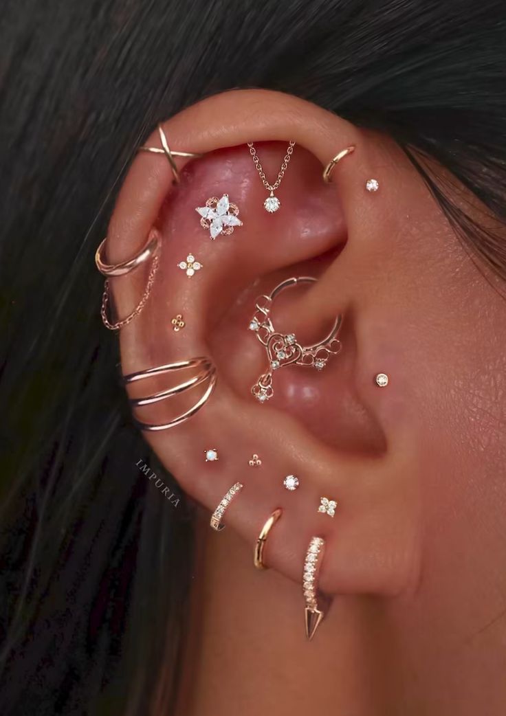 a woman wearing multiple ear piercings with different designs