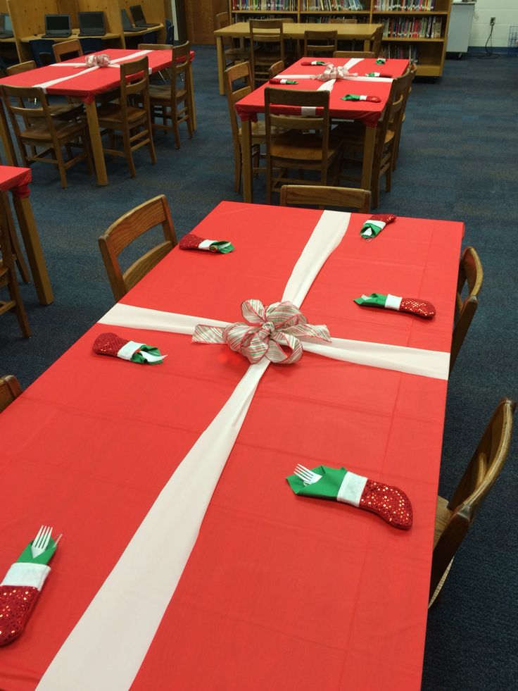 the table is set with red and white cloths, silver bows, and green napkins