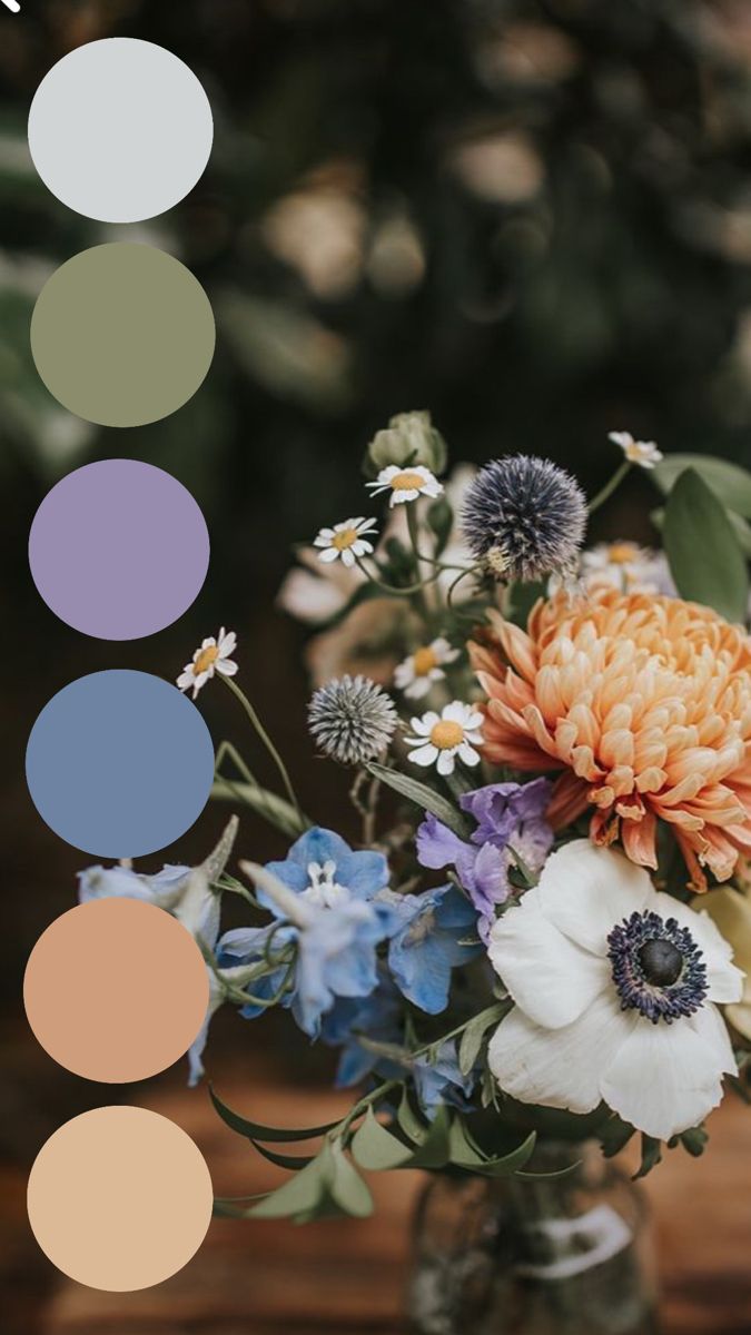 a vase filled with lots of flowers on top of a wooden table next to a color wheel