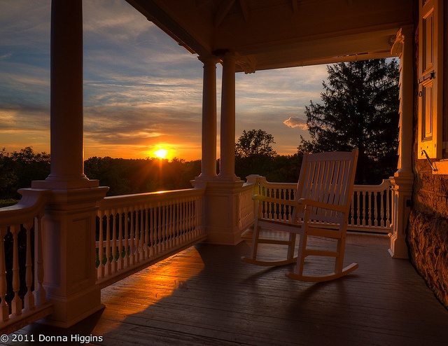 a rocking chair sitting on top of a wooden porch