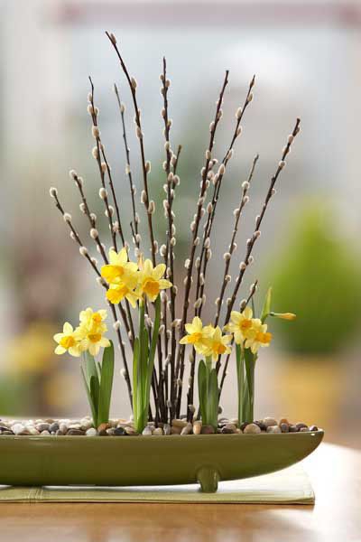 a vase filled with yellow flowers sitting on top of a table