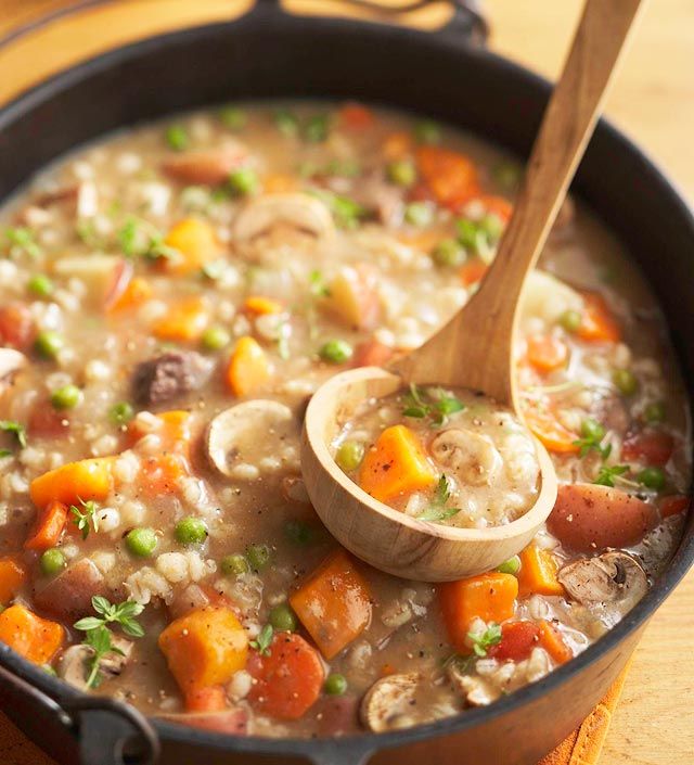 a wooden spoon in a pot filled with soup