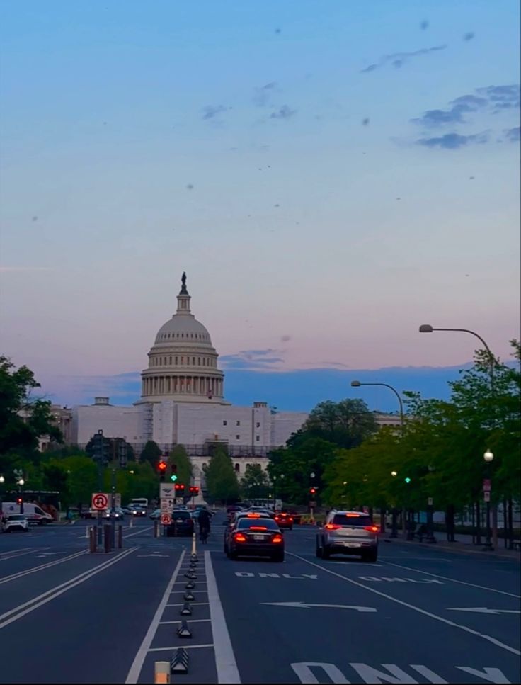 the capitol building in washington d c is seen from across the street at dusk time