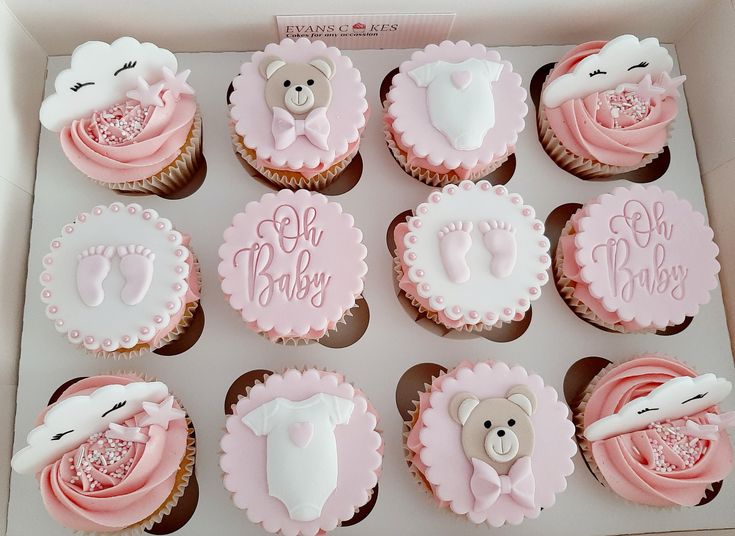 twelve cupcakes in a box with pink frosting and teddy bears on them