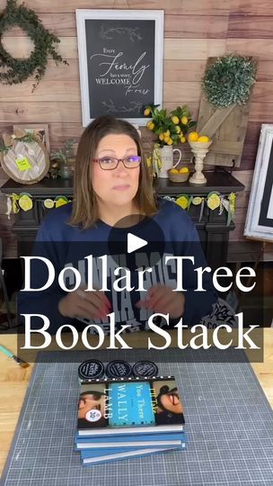 a woman sitting in front of a table with books on it and the words dollar tree book stack