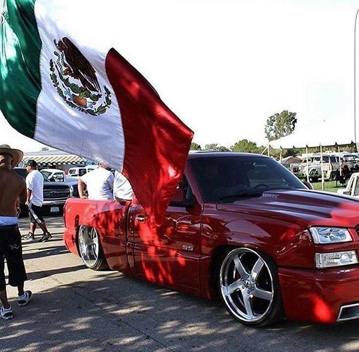 a red truck with a mexican flag on it's hood