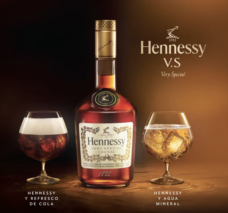 a bottle of hennessy vs next to two wine glasses