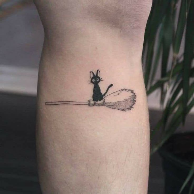 a small black and white mouse tattoo on the right side of the leg, with a spiky tail