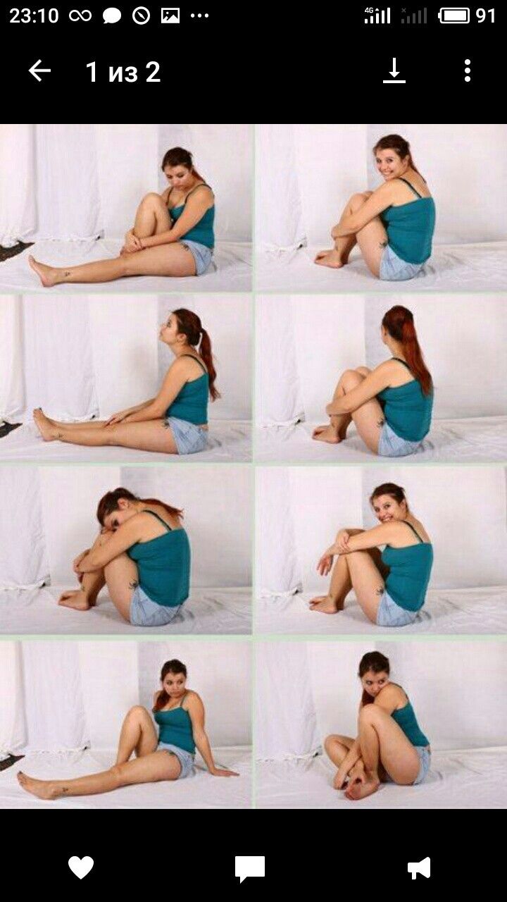 a woman sitting on top of a bed next to a white wall and posing for the camera