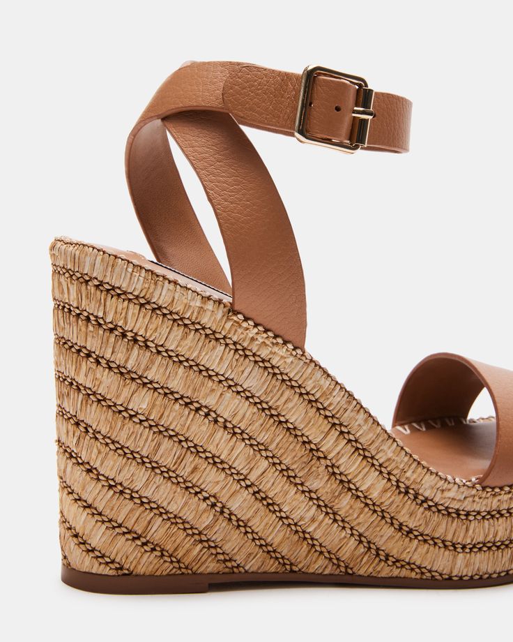 SUNNY + PRETTY + MODERN The CASSIE square toe sandal is set on a platform wedge sole wrapped in woven raffia in diagonal stripes and finished with whipstitching over the top. Square toe platform wedge sandal Crossed ankle straps with buckle closure Woven raffia wrapped platform wedge sole Whipstitch detail around welt 4.25 inch heel height 1.25 inch platform Leather upper material Synthetic lining Synthetic sock Synthetic sole imported Straw Wedge Sandals With Woven Sole And Ankle Strap, Natural Straw Wedge Sandals With Ankle Strap, Ankle Strap Wedge Sandals With Woven Straw Sole, Brown Straw Wedge Sandals For Summer, Chic Brown Straw Wedge Sandals, Summer Brown Straw Wedge Sandals, Natural Wedge Sandals With Woven Sole And Ankle Strap, Brown Wedge Sandals With Ankle Strap And Woven Sole, Natural Wedge Sandals With Ankle Strap And Woven Sole