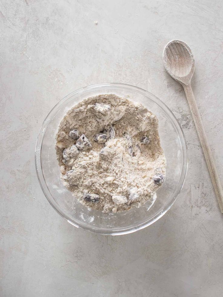 a glass bowl filled with oatmeal and blueberries next to a spoon