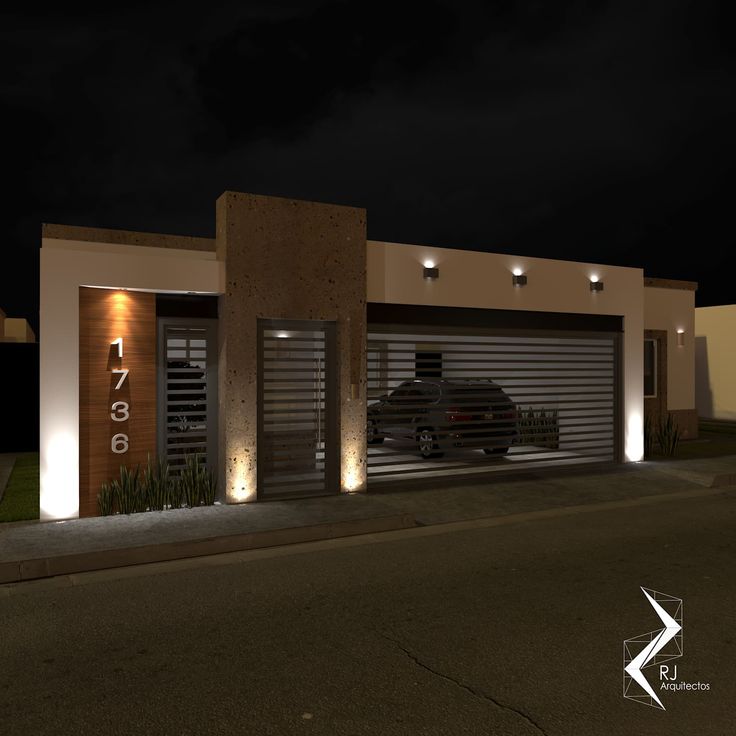 a car is parked in front of a house at night with lights on the garage door